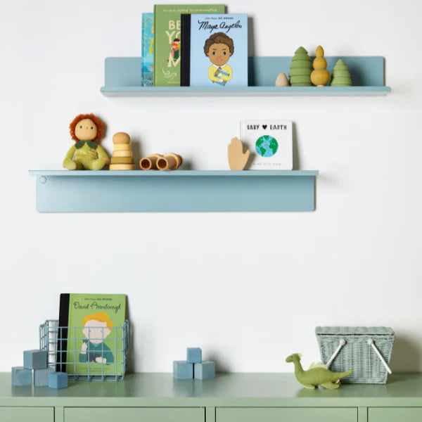 Children's room with shelves displaying books and toys against a white wall.