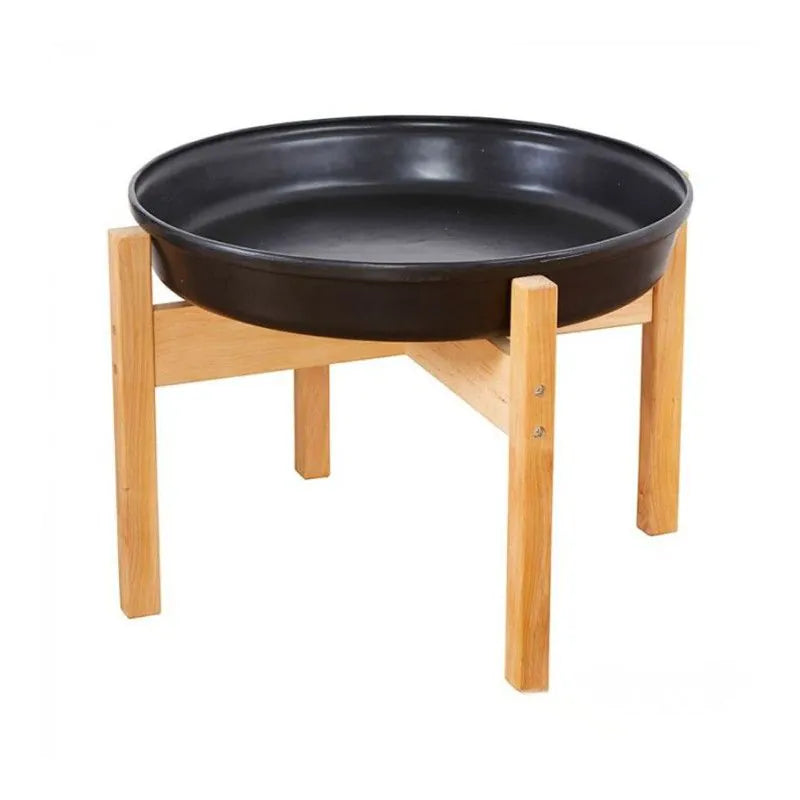 Black round pan on a wooden stand against a white background