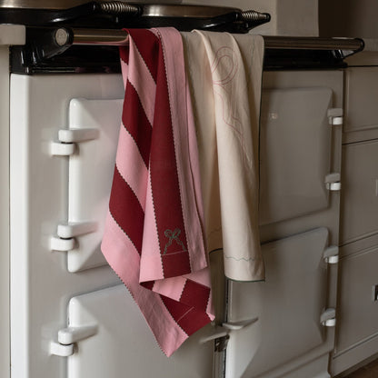 Towels hanging on a rack attached to a large kitchen appliance.