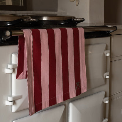 Striped red and pink towel hanging on a vintage-style oven.