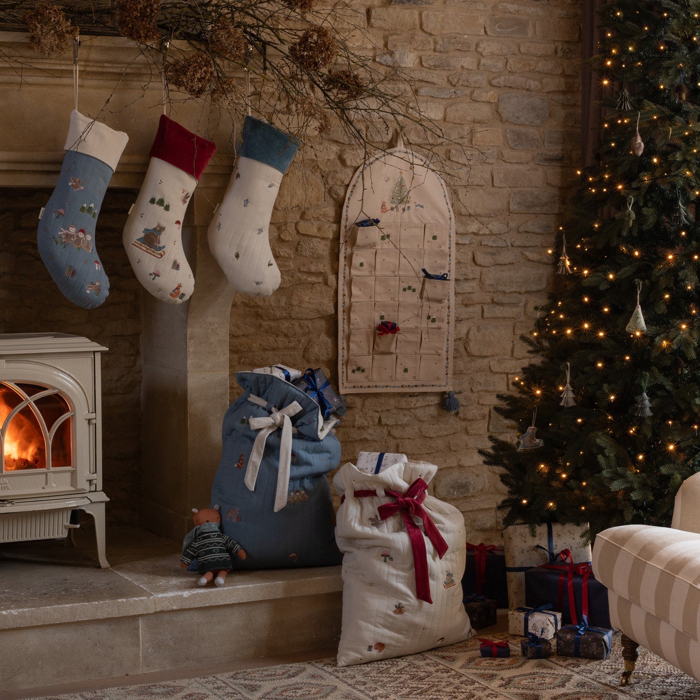 Cozy living room with Christmas stockings, tree, and fireplace.