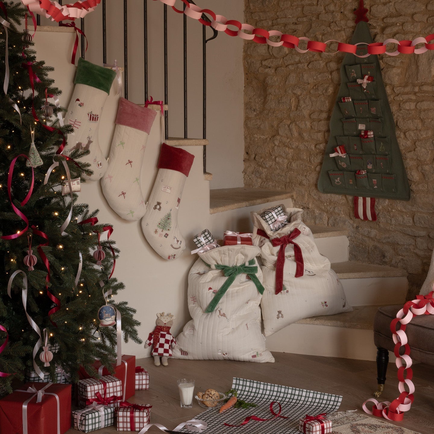 Decorated Christmas living room with stockings, tree, and presents.