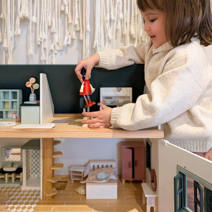 Child playing with a toy in a miniature room setup