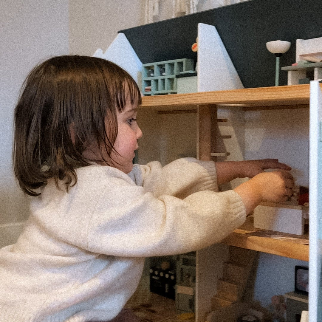 Child playing with a toy kitchen set