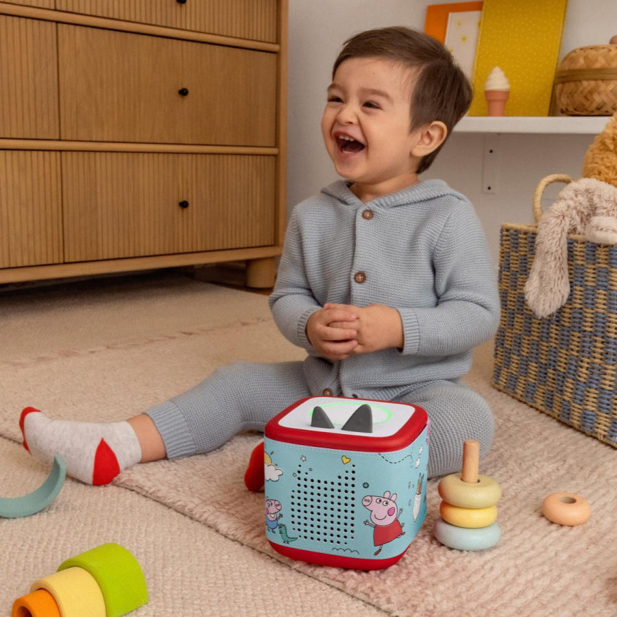 Child playing with a toy in a room with wooden furniture and toys.