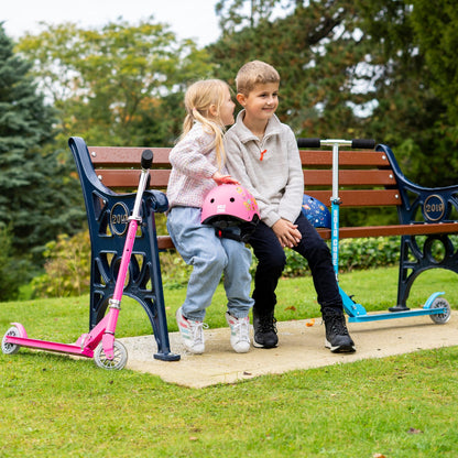 Two children with scooters sitting on a park bench