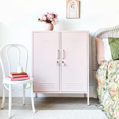 Pink cabinet in a room with a chair and bed