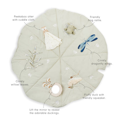 Round fabric play mat with various interactive elements on a light green background