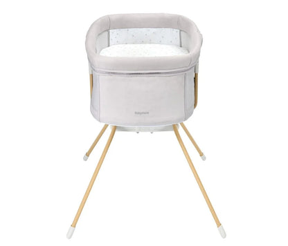 Baby bassinet with wooden legs on a white background