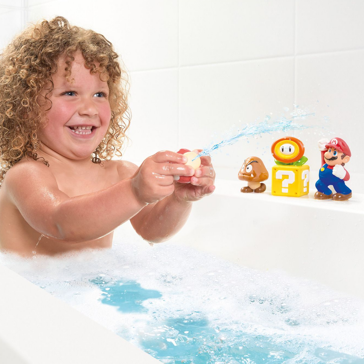 Child playing with bath toys in a bathtub, including characters from a popular video game series.