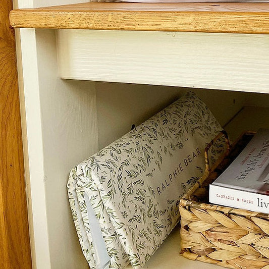Bookshelf with a wrapped book and a basket on a wooden shelf