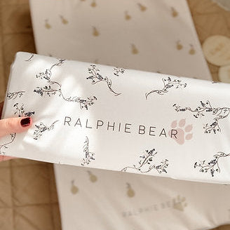 Ralphie Bear product packaging held by a hand with a blurred background