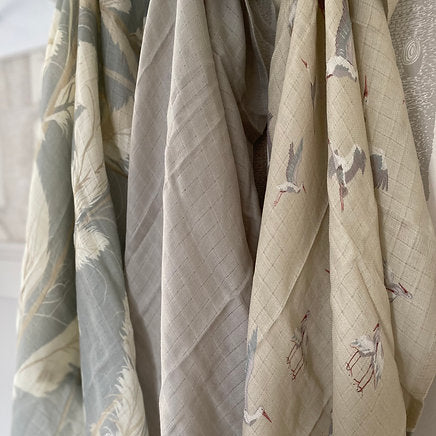 Set of fabric swatches with various patterns and colors hanging against a white background.