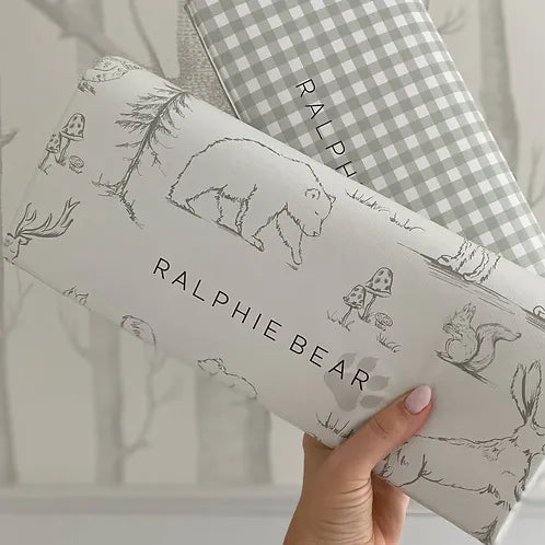Two children's pillows with 'Ralphie Bear' branding and illustrations on a neutral background.