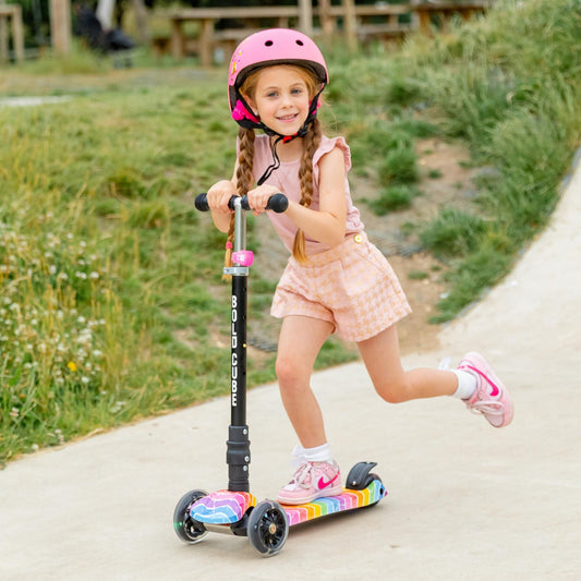 Child riding a scooter with a helmet on a path outdoors