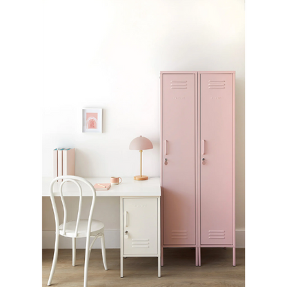 Pink locker next to a white desk with a chair in a room setting.