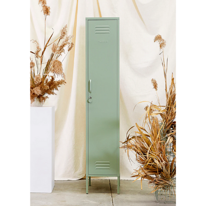 Green metal locker with dried plants on a light background