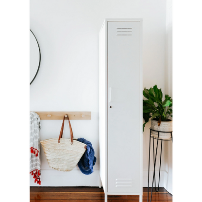 White locker with a bag and jacket on a wooden bench against a white wall.