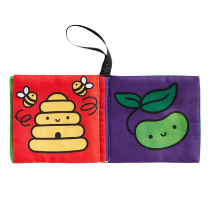 Children's soft book with bee, beehive, and apple illustrations on a white background