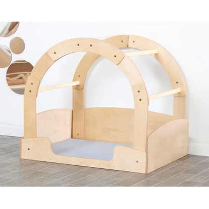 Wooden playhouse with a dome-shaped roof on a tiled floor.