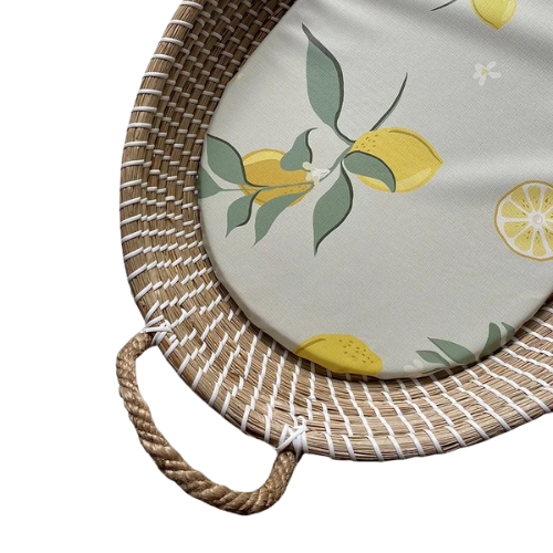 Round cushion with lemon design on a woven mat