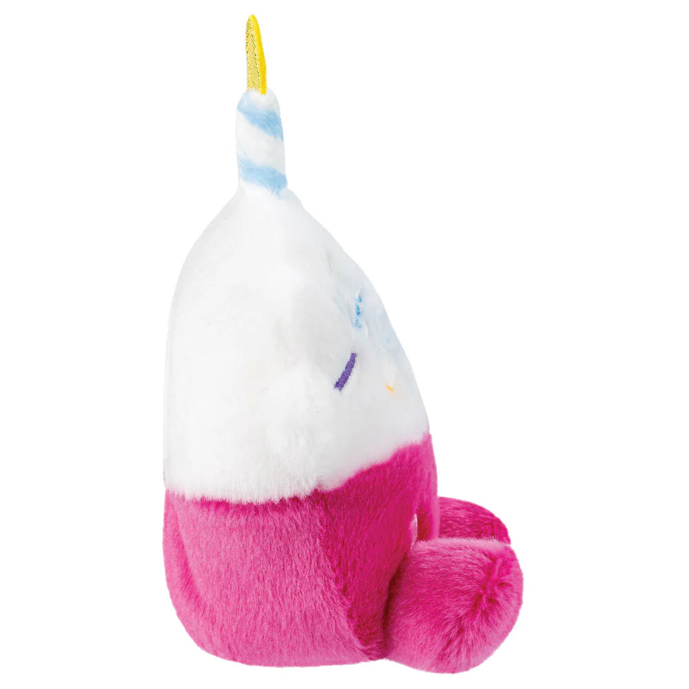 Plush toy with a unicorn horn and pink body on a white background