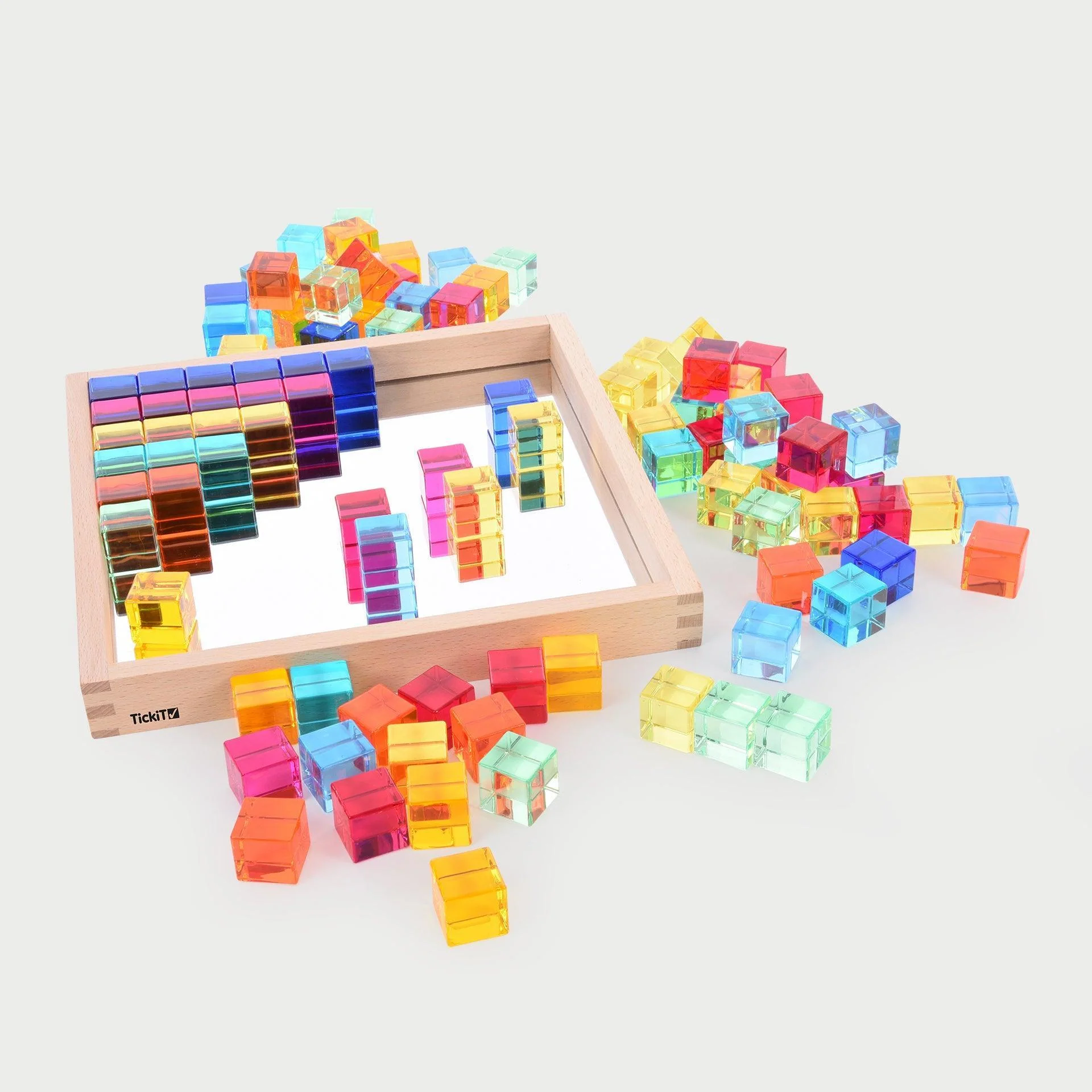 Acrylic cubes in a tray and surrounding the wooden tray.