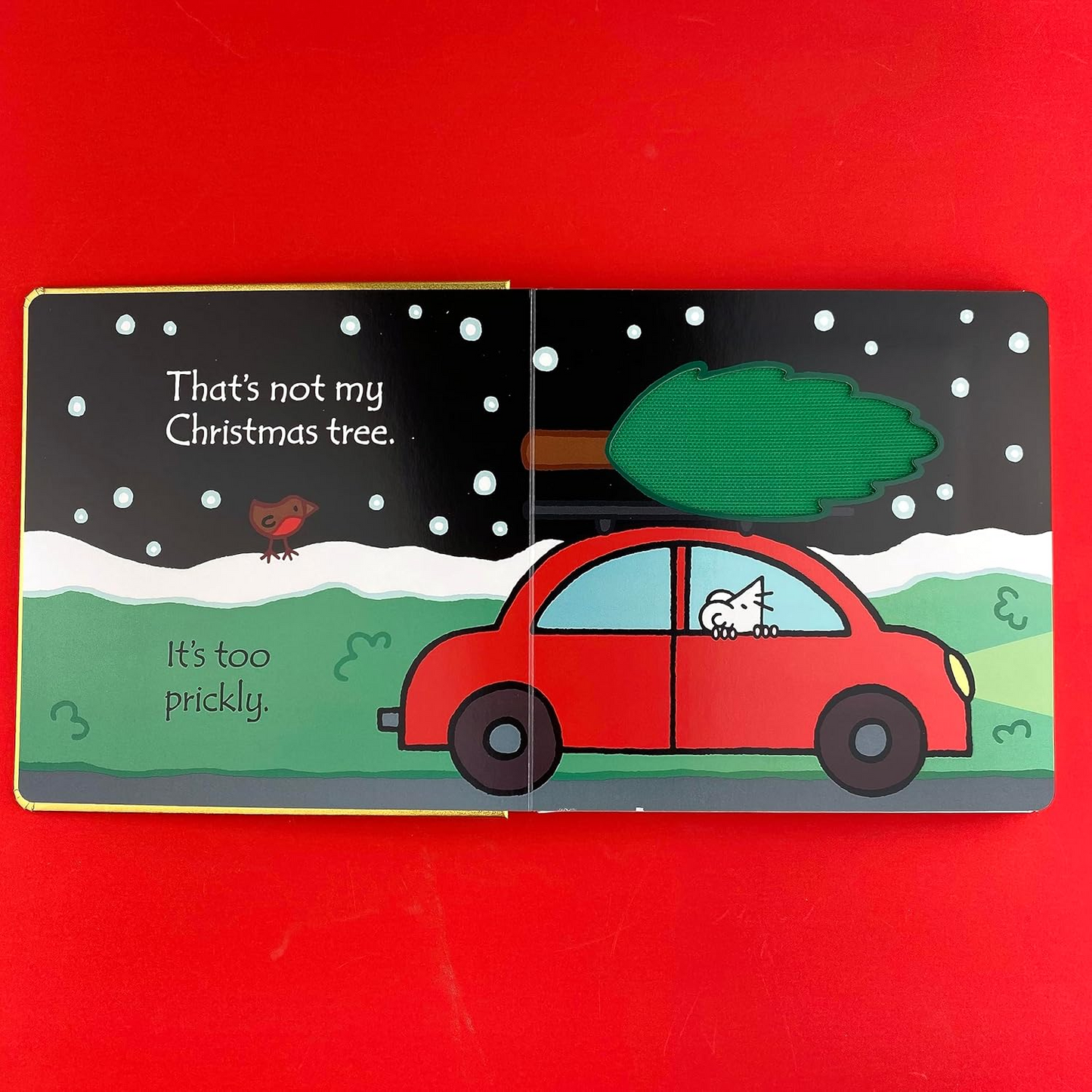 Illustrated book page with a red car and Christmas tree on a red background