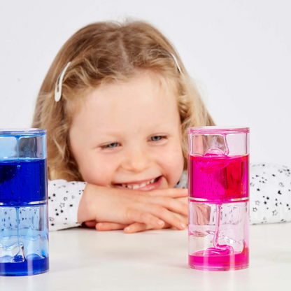 Child with colourful water sensory bottles on a white background