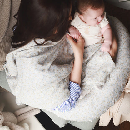 Woman holding a baby wrapped in a floral blanket