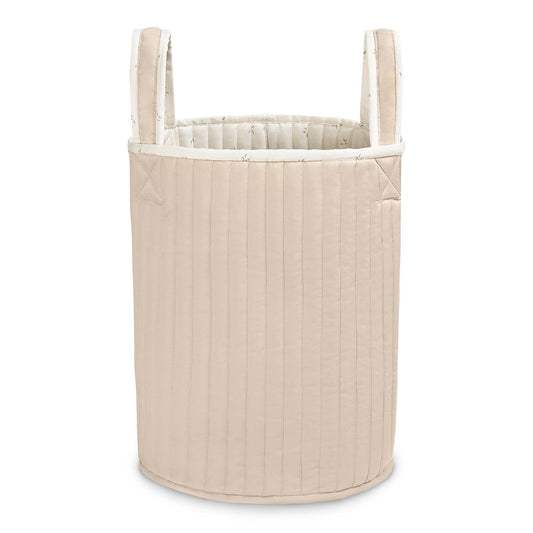 Beige quilted laundry basket with handles on a white background