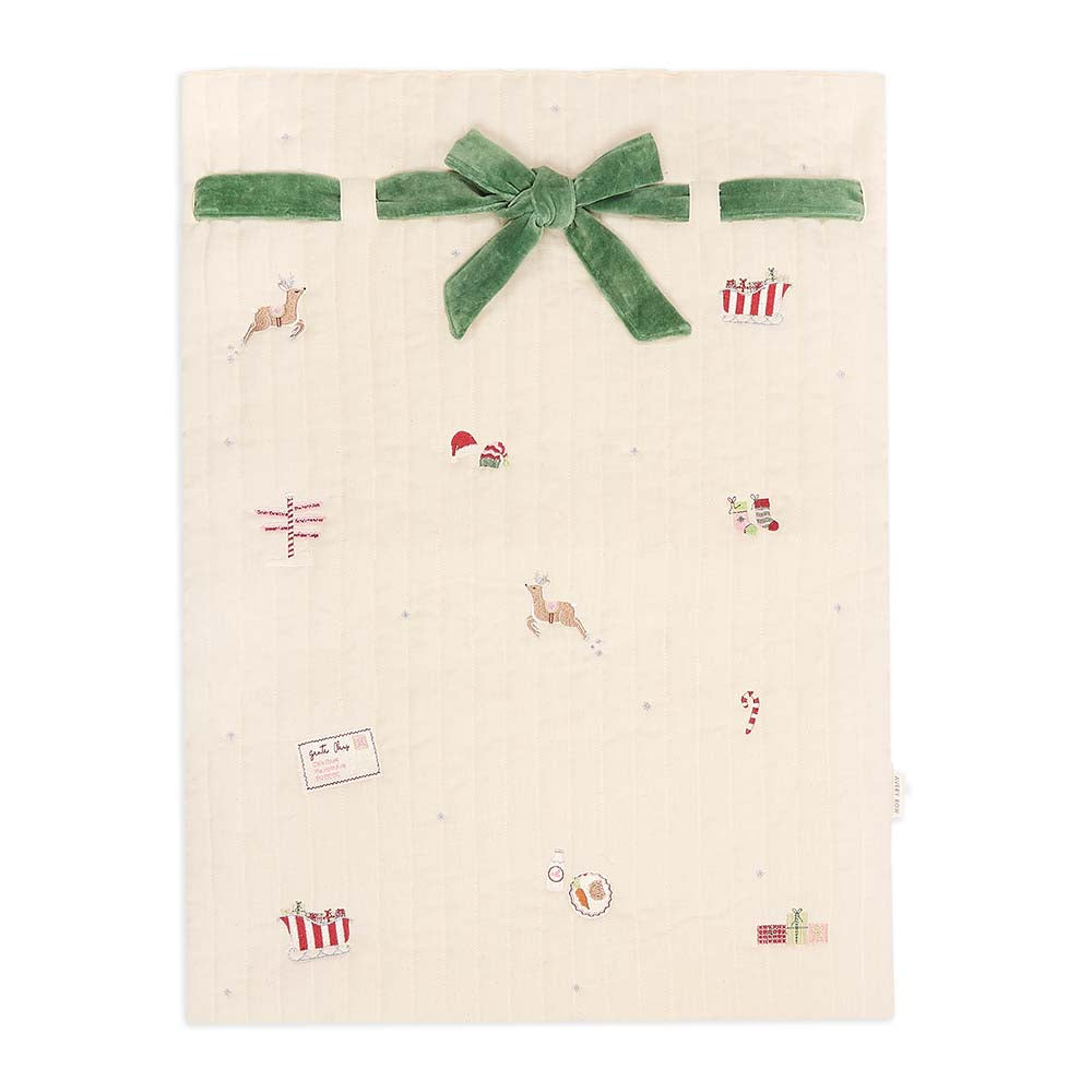 Beige fabric with Christmas-themed patterns and a green bow on a white background