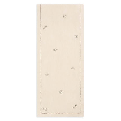 Beige table runner with embroidered butterfly designs on a white background