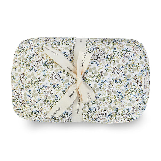 Folded floral blanket with a ribbon on a white background