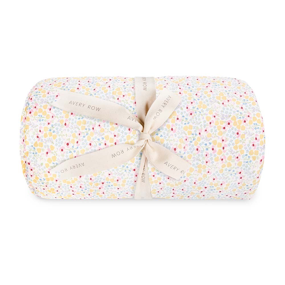 Folded baby blanket with floral pattern and ribbon on a white background