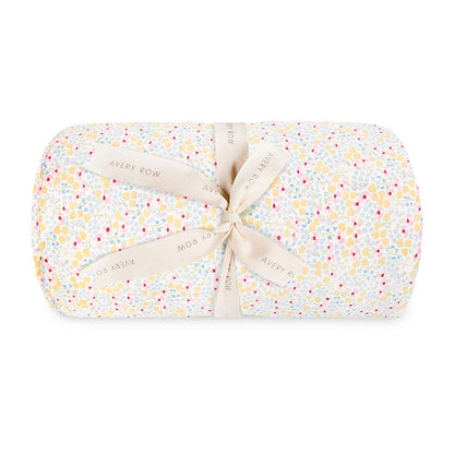 Folded baby blanket with floral pattern and ribbon on a white background
