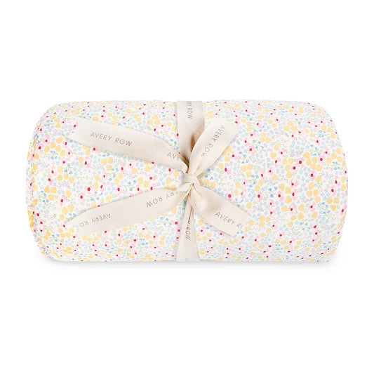 Folded baby blanket with floral pattern and ribbon on a white background