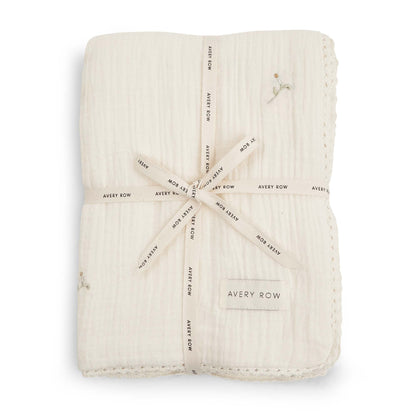 Folded beige fabric swaddle with 'Avery Row' branding on a white background