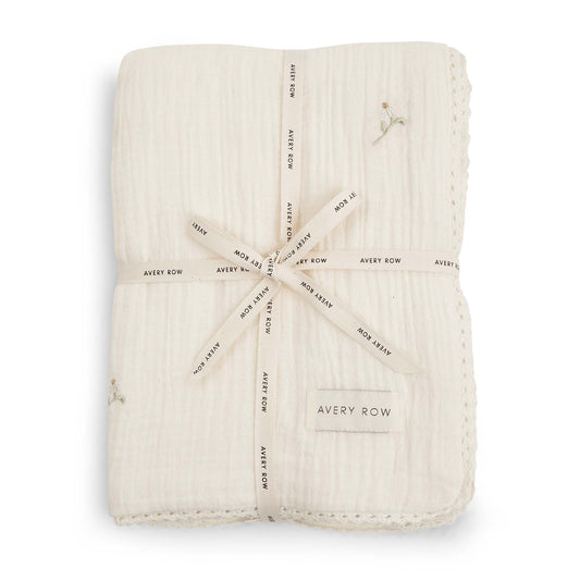 Folded beige fabric swaddle with 'Avery Row' branding on a white background