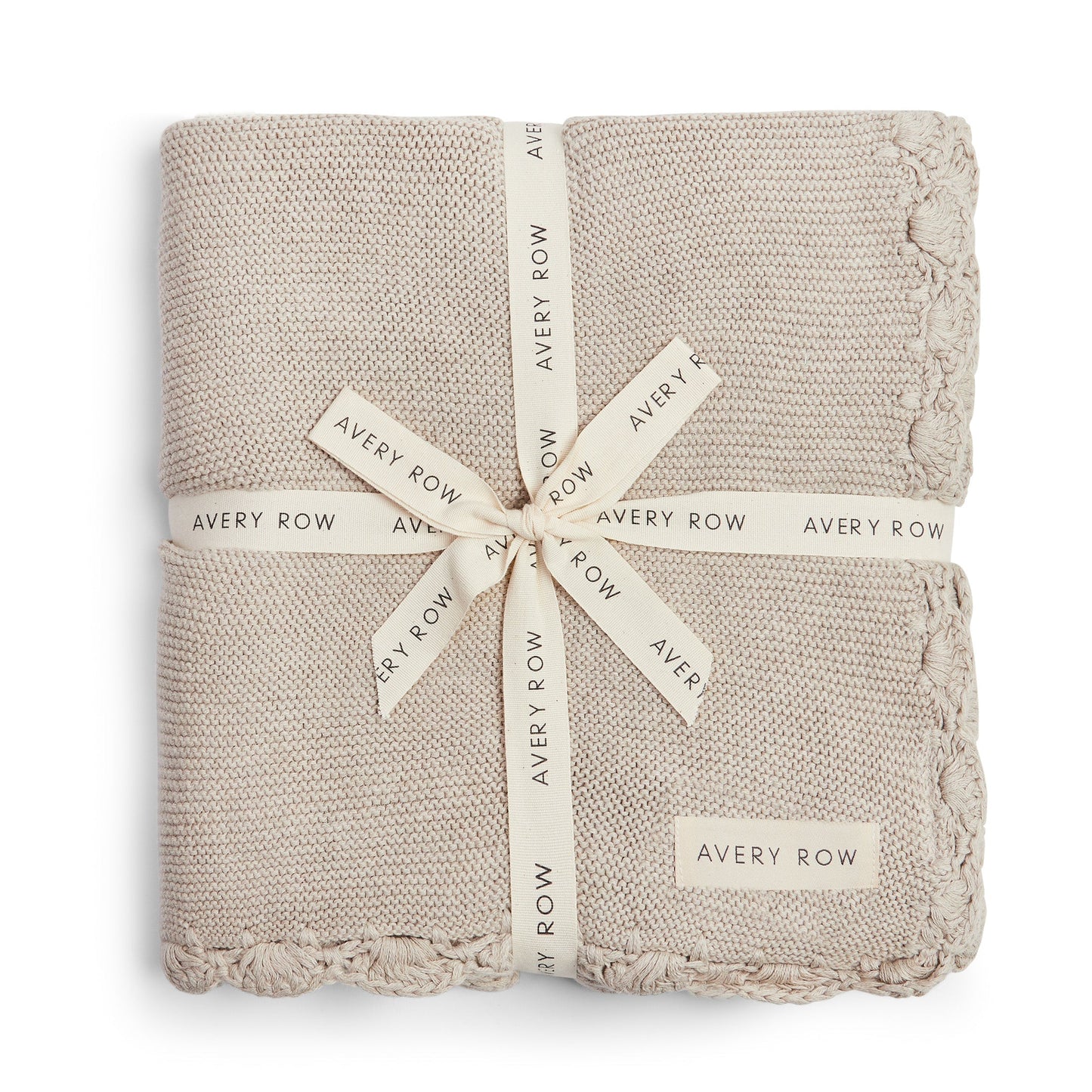 Folded beige blanket with 'Avery Row' branding on a white background