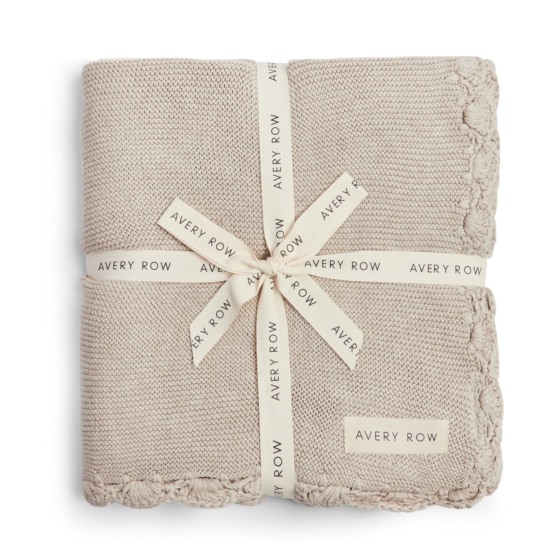 Folded beige blanket with 'Avery Row' branding on a white background