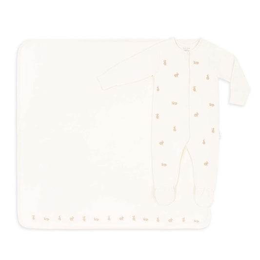 White baby onesie with gold accents on a white background