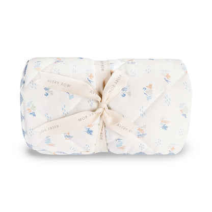 Folded baby blanket with floral pattern and tied bow on a white background