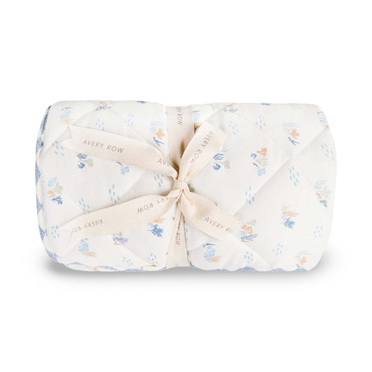 Folded baby blanket with floral pattern and tied bow on a white background