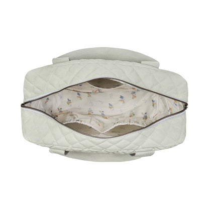 Quilted baby changing bag with floral lining on a white background
