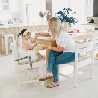 Woman and child sitting at a table in a bright, modern kitchen.