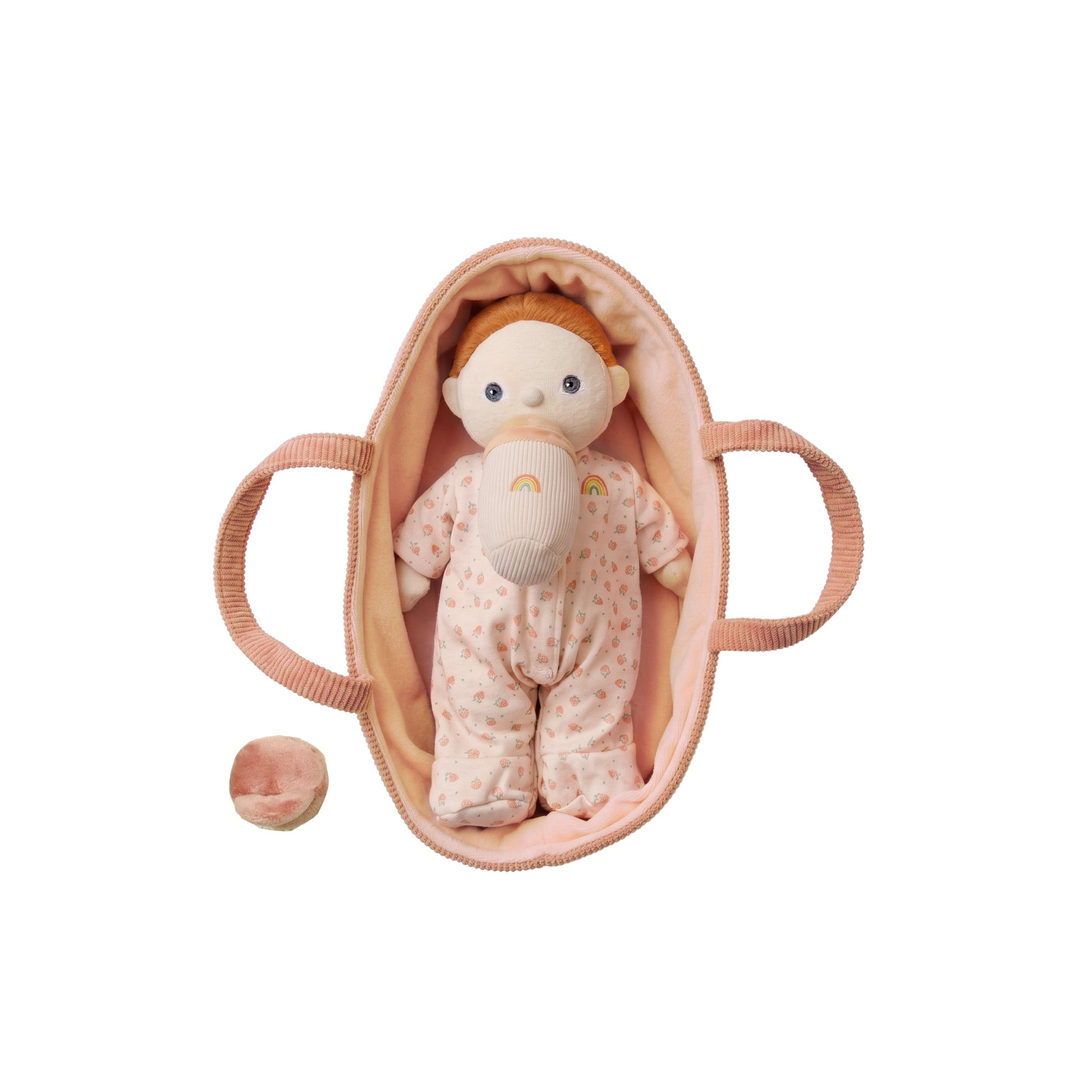 Baby doll in a pink crib on a white background