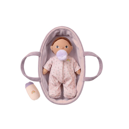 Baby doll in a crib with a pacifier on a white background