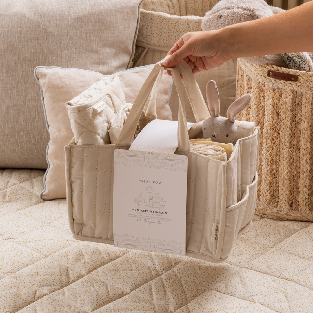 Beige baby organizer with a plush toy and book on a beige couch