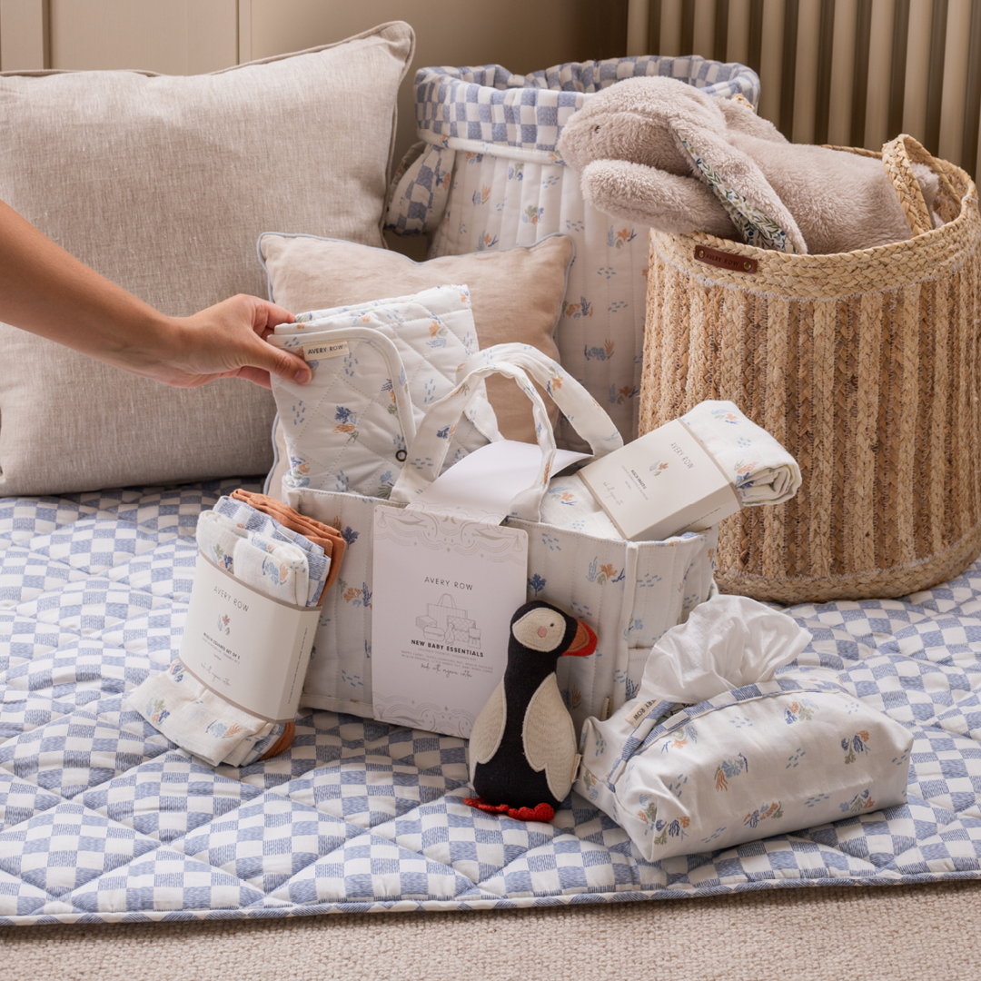Baby gift basket with items on a checkered blanket